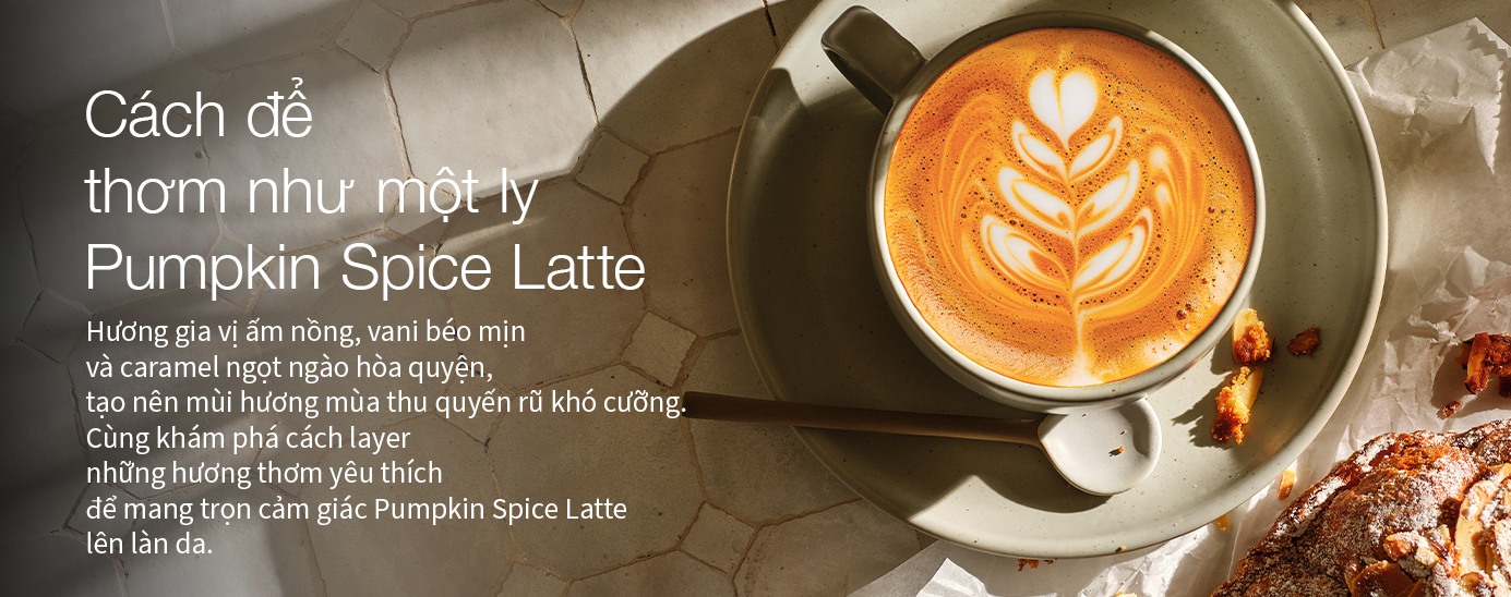A pumpkin spice latte with latte art on a marble surface